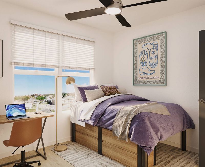 Sterling Quadrangle A tidy dorm room with a single bed, desk, laptop, window, wall art, and a ceiling fan.